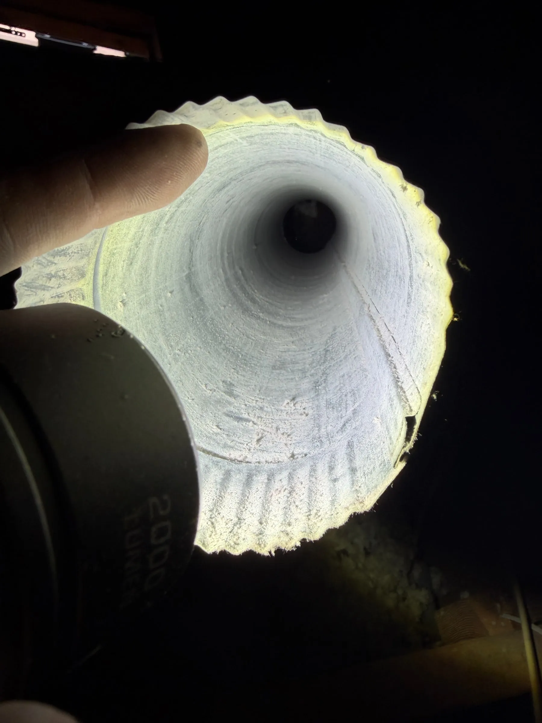 A dryer vent duct after cleaning, clear all the way through under a flashlight